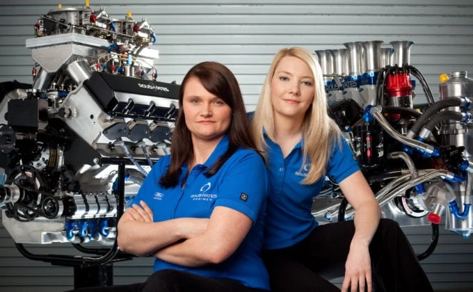 Student portraits in front of engine